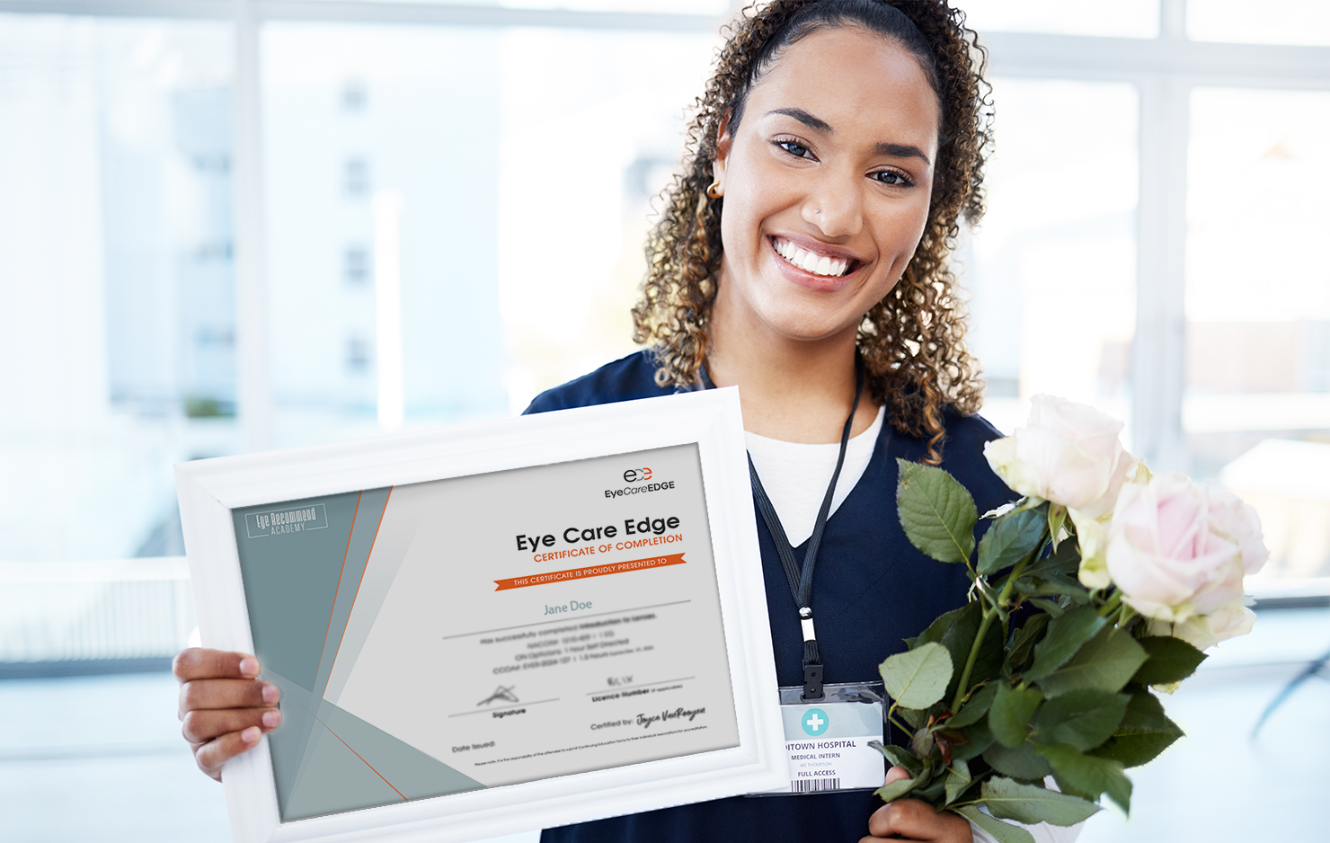 Young female optometrist is facing the camera. She is holding a frame Eye Care Edge Certificate in one hand and a bouquet of flowers on the other.
